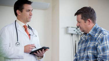 Man sitting in doctor's office with doctor