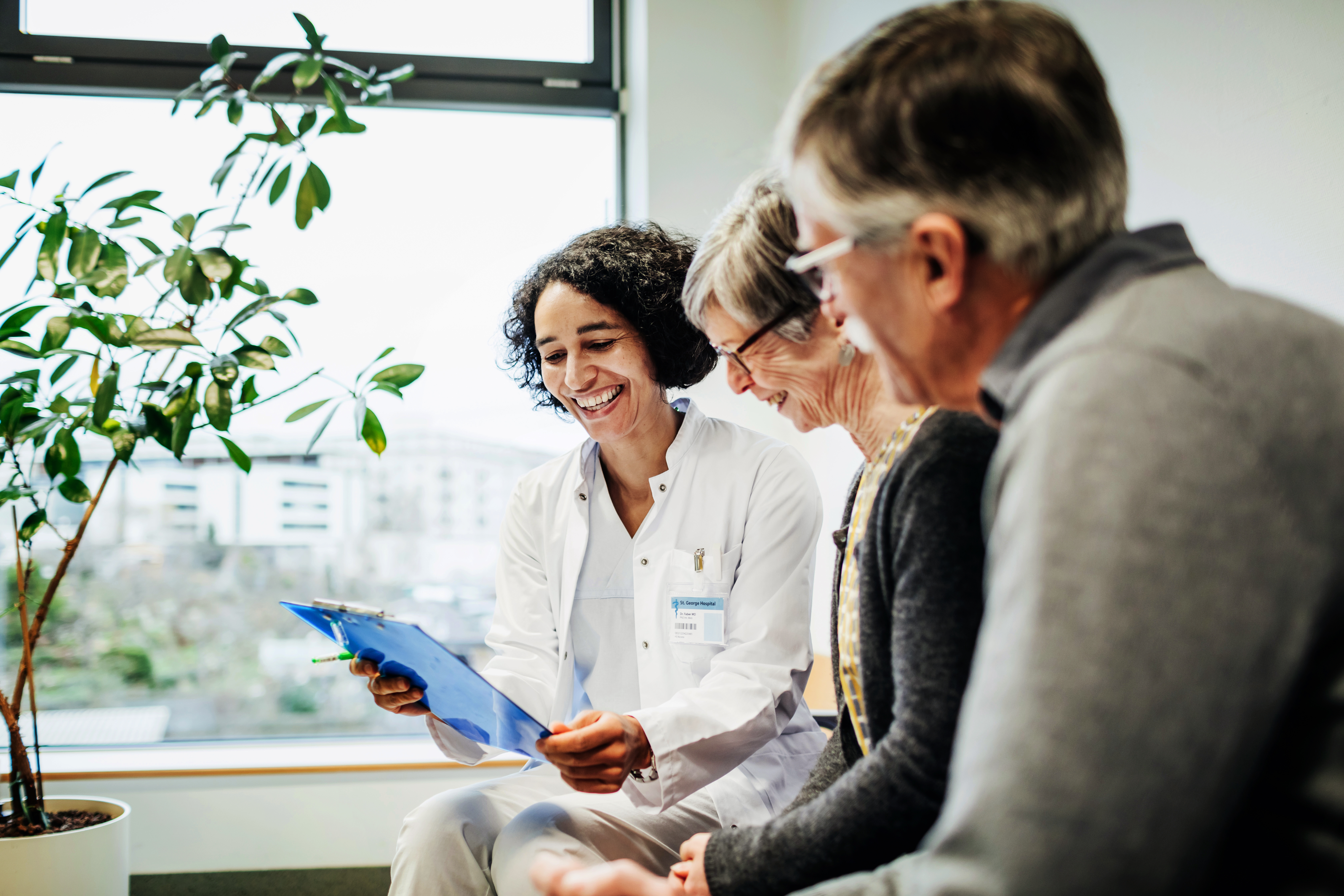 Provider with two patients looking at a tablet.
