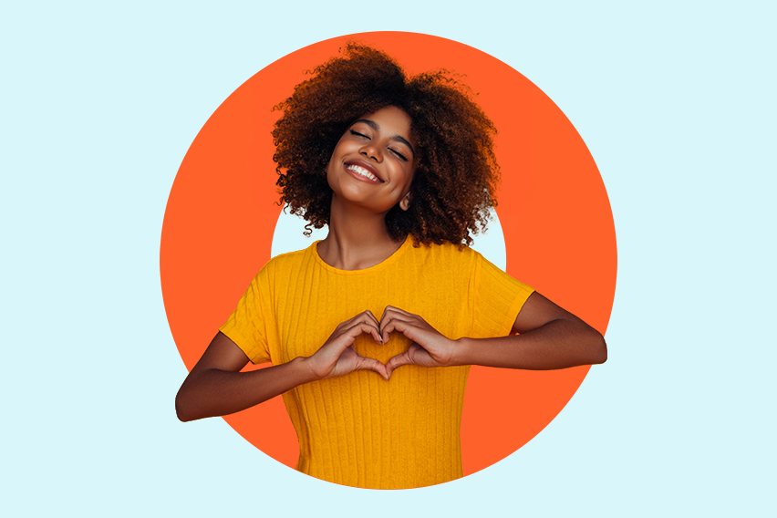 Happy young woman making a heart shape with her hands