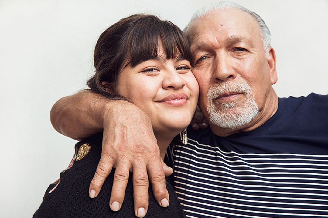 Man embracing teenage granddaughter