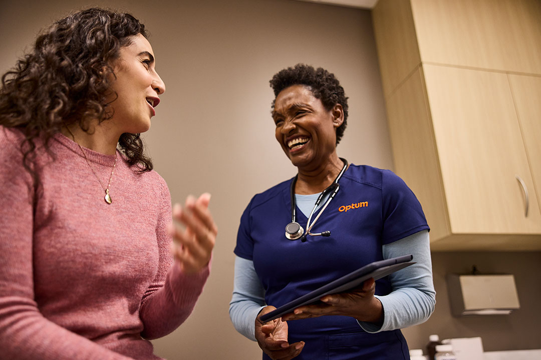 Smiling woman and nurse in exam room 