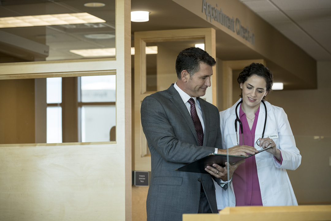 Businessman reviewing paperwork with female doctor