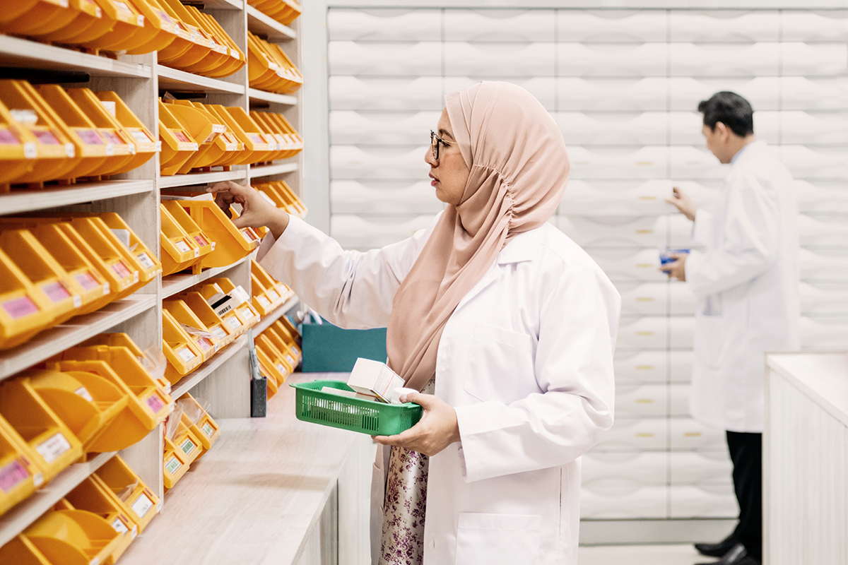 Pharmacist wearing a head scarf organizing medication