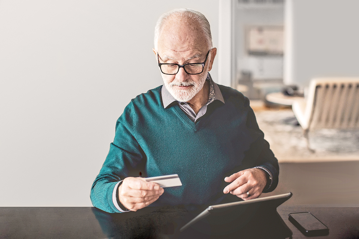 Older man looking up eligible medical expenses on his tablet