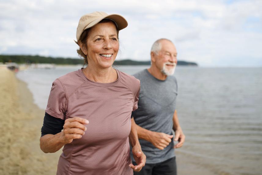 An older couple jogging on the beach