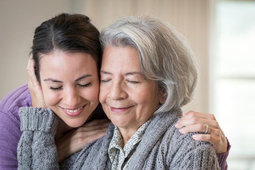 Caregiver and patient hugging and smiling