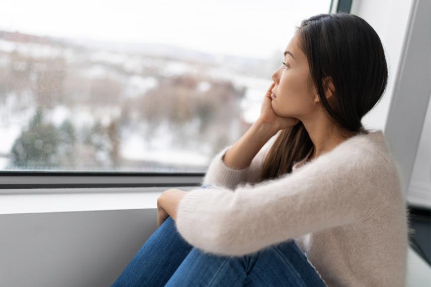 A depressed woman looking out the window