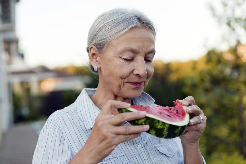 A woman eating a slice of watermelon