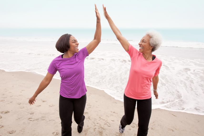Two women jogging at the beach to help maintain a healthy weight