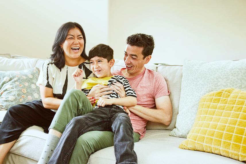 A family laughing together on the couch