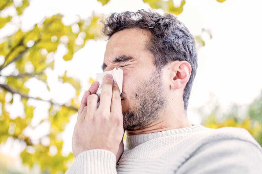 A man blowing his nose outdoors
