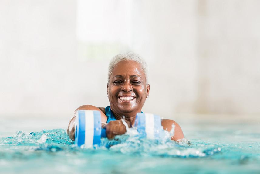 An older woman doing pool workouts with a water weight