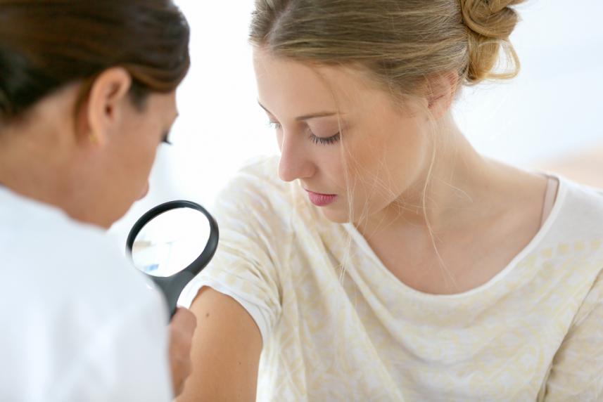 Doctor examining a spot on patients skin