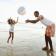 Man and child on a beach playing with a beach ball
