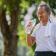 An older man drinking water after exercising outside