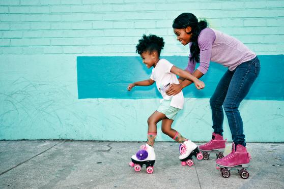 A mother helping her child learn how to roller skate