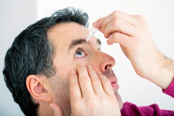 Man using eye drops to relieve dry eye