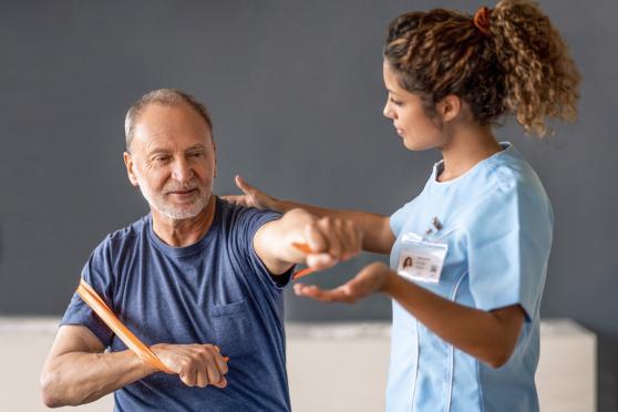 A physical therapist helping an older man