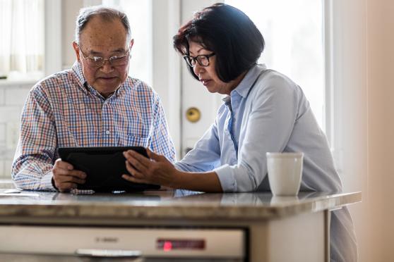 Senior couple looking at a tablet in the kitchen