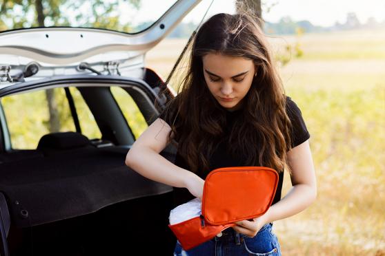 Woman packing first-aid essentials for a road trip