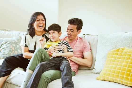 A family laughing together on the couch