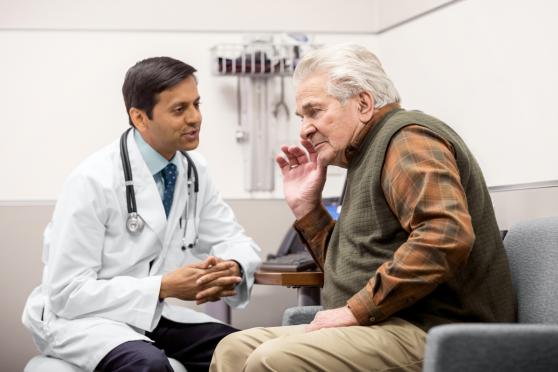 Elderly person visiting doctor about hearing loss