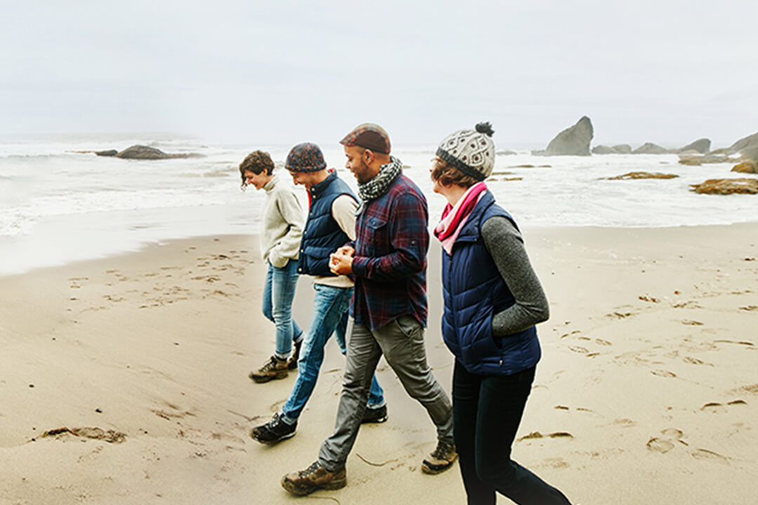 Laughing friends exploring beach